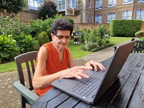 Image of a woman sitting at a table with a laptop