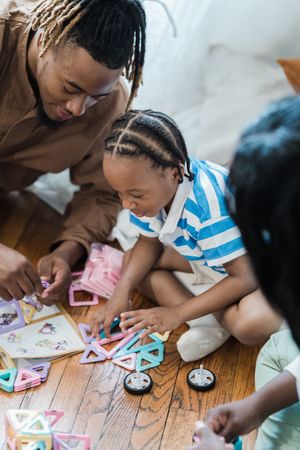 Image of dad and child playing with toys on the floor