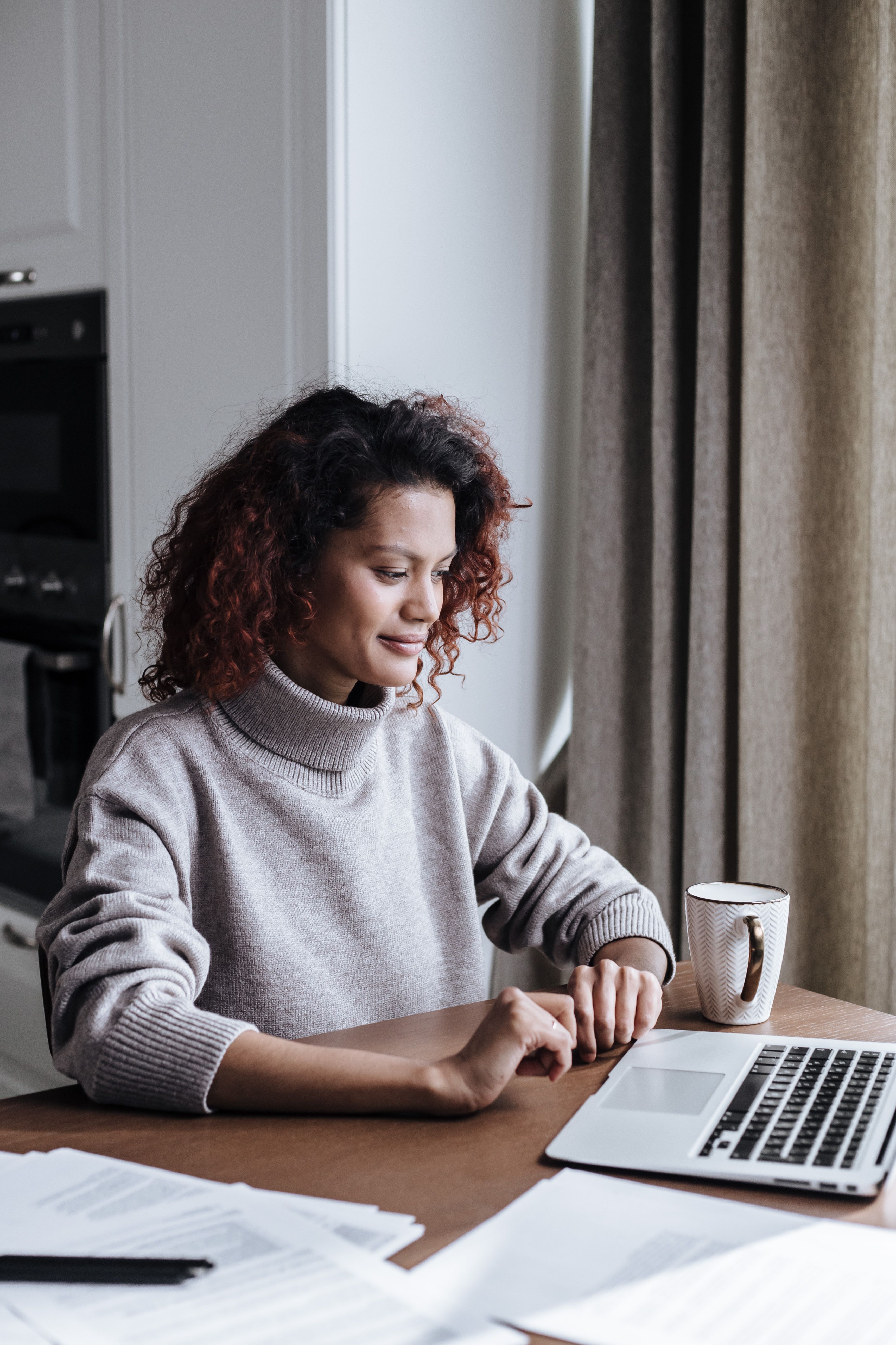 Image of woman sitting with a laptop working