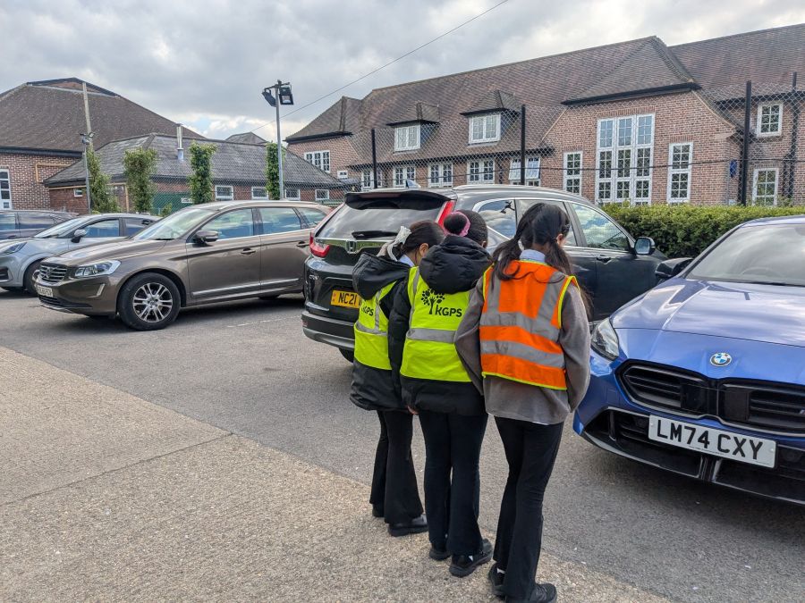 Kingsbury school children in high vis jackets looking at a car
